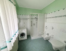 Badezimmer mit Duschkabine, Waschmaschine, WC und Bidet