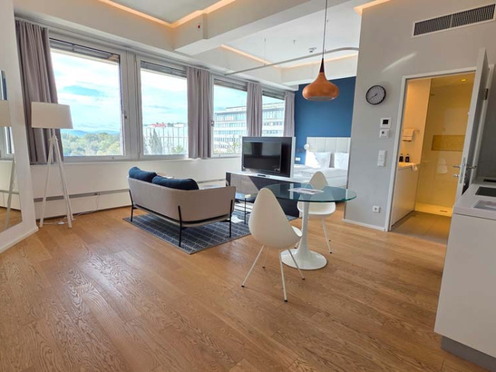 Blick ins grosse Wohnzimmer mit Doppelbett und Sitzgarnitur in moderner Wohnung Triesterstr in 1100 Wien verkehrsgünstig gelegen